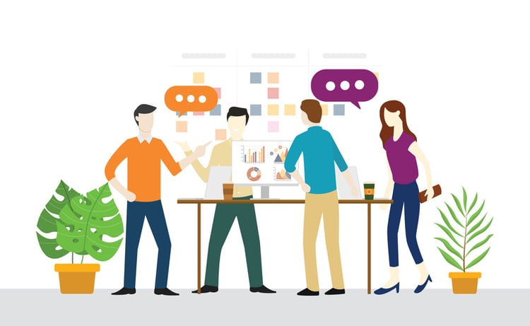 Team collaborating around a table with laptops, charts, and sticky notes, representing tools that enhance daily standup meetings through planning, communication, and task tracking.