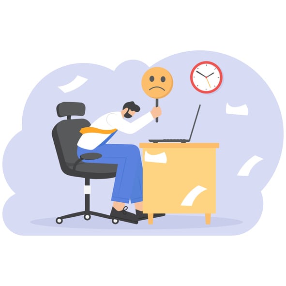 Illustration of a tired employee slouched at a desk holding a sad emoji sign, surrounded by scattered papers and a clock.