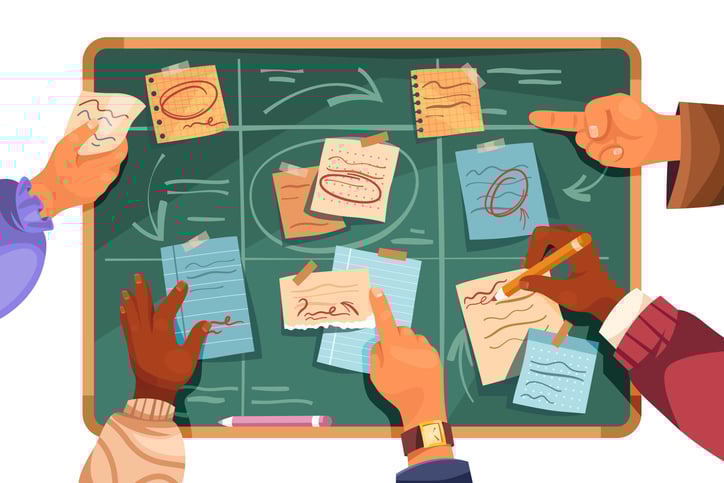 eam collaborating around a chalkboard filled with flowcharts, notes, and strategy diagrams, representing key elements of an effective product roadmap 